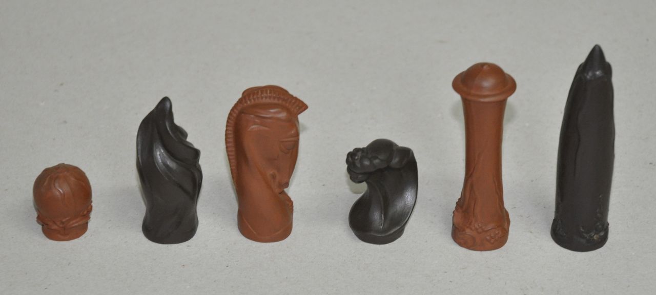 Max Esser | A Meissen stoneware chess set and an inlaid ivory hardwood chess board, Böttger-stoneware, 8.2 x 2.5 cm, signed incised with factorymark and serial numbers and executed second quarter 20th century