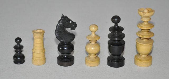 Schaakset, opbergdoos   | A French or German 'Régence' style boxwood and ebonised chess set, in a red walnut box, palmwood and ebony 7.8 x 3.7 cm, executed 1920